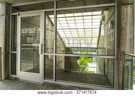 Glass Door And Wall With View Of Slanted Frosted Roof Over Stairway Of Building