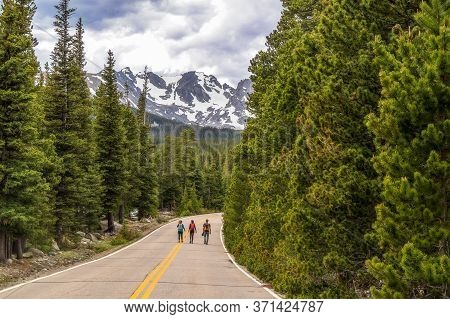 Unrecognizable Tourists Walking On The Road To Brainard Lake And Indian Peaks Near Nederland, Colora