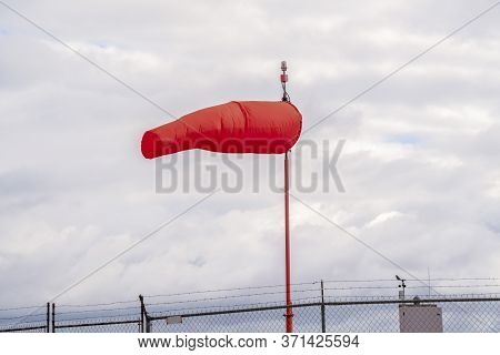 Red Wind Sock At An Airport Blowing In The Wind