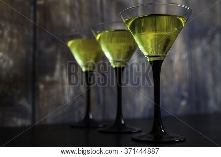 Three Yellow Cocktails Glasses In Line