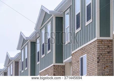 Vertical Siding And Stone Brick Wall At The Townhomes Upper Storey Against Sky