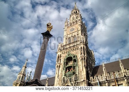 Sityscape with St. Mary's column and The New Town Hall on Marienplatz square on a background of blue cloudy sky, Munich, Bavaria, Germany