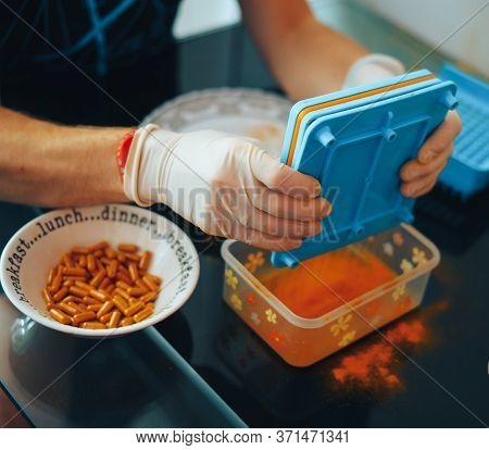 Mans Hands In Gloves Making Home Made Pills And Vitamins With Organic Turmeric Powder Using Special 