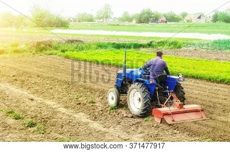 Farmer On A Tractor With Milling Machine Loosens, Grinds And Mixes Soil. Loosening The Surface, Cult