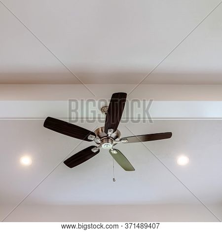 Square Frame Ceiling Fan With Wood Blades And Built In Lights On The Ceiling Beam Of Home