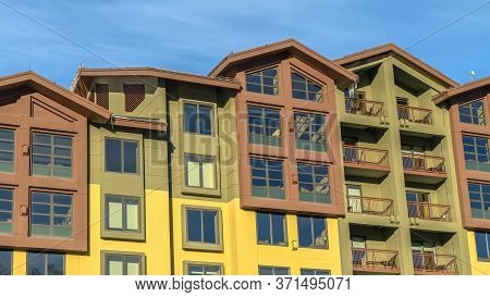 Panorama Residential Building With Multi Color Wall And Small Balconies Against Blue Sky