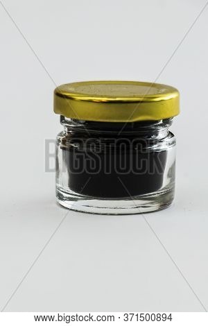 Small Glass Jar Of Dark Honey With Metallic Cap Isolated On A White Background.