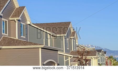 Panorama Row Of Houses In A Suburb Neighborhood With Mountain And Blue Sky Background