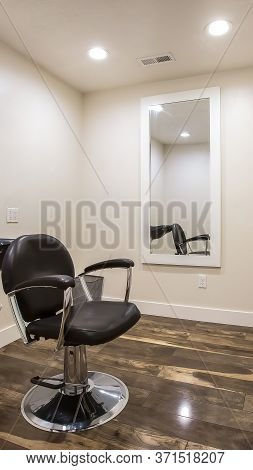 Vertical Crop Hairdresser Chair And Backwash Shampoo Bowl Inside Salon With Bench And Mirror