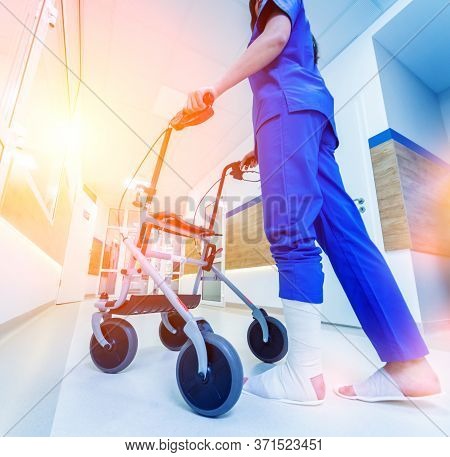Patient On Rollator With Hand Brakes Moving In Hospital