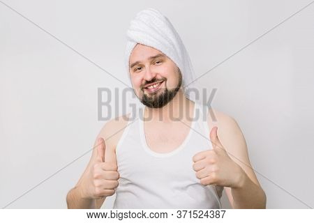 Happy Smiling Caucasian Bearded Man In Whilte T-shirt And With A Towel On His Head Posing To Camera 