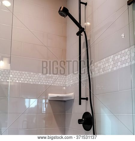 Square Crop Black Round Shower Head On Tile Wall Of Shower Stall With Hinged Glass Door