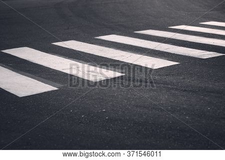 White crosswalk stripes on an city street. Road safety, traffic calming measures.