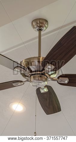 Vertical Electrical Fan With Built In Lights Installed On Decorative Wooden Ceiling Beam