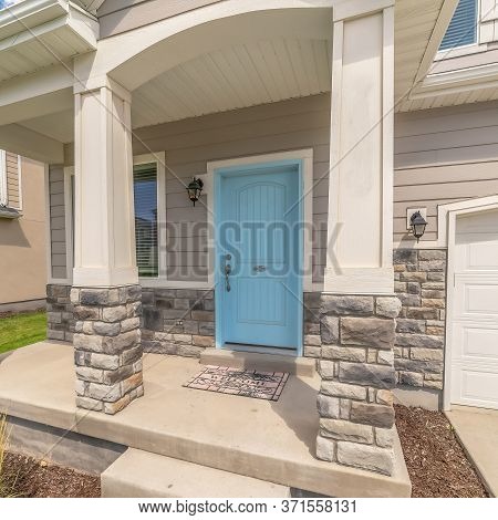 Square Stape And Arched Entrance At The Porch Of Home With Pastel Blue Front Door