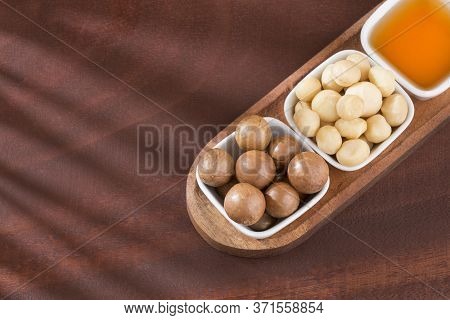 Organic Macadamia Nut On Wooden Table - Macadamia Integrifolia