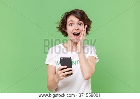 Excited Young Brunette Woman In White Volunteer T-shirt Isolated On Pastel Green Background. Volunta