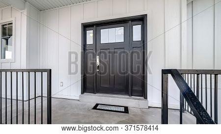 Panorama Crop Home Entrance With Front Porch And Black Front Door Against White Panelled Wall