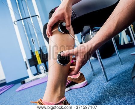 Physical Therapist Install Electrostimulator On The Muscles Of The Legs