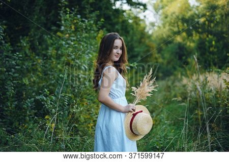 Beautiful Girl In A White Dress With A Bouquet Of Dried Flowers. Young Woman In A Green Park. Girl I