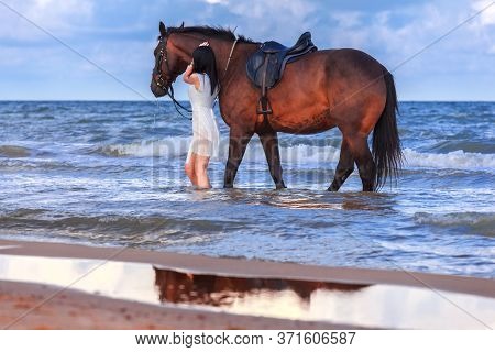 Beautiful Young Girl With A Horse On The Beach Early In The Morning