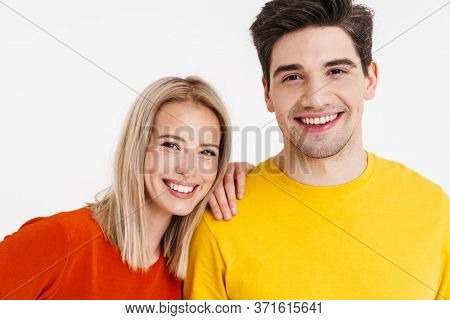 Image of cheerful young man and woman smiling and looking at camera isolated over white background