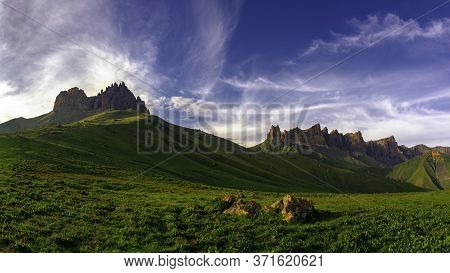 Mountains Above Green Meadows Under A Blue Sky