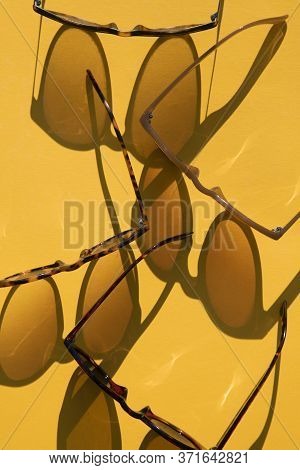 Sunglasses With Long Shadow On A Brignt Summer Yellow Background