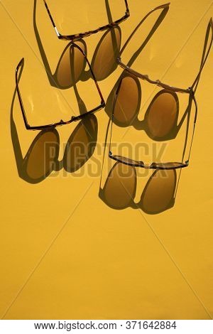 Sunglasses With Long Shadow On A Brignt Summer Yellow Background