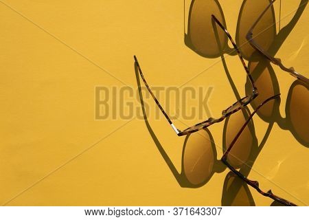 Sunglasses With Long Shadow On A Brignt Summer Yellow Background