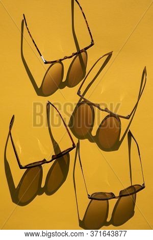 Sunglasses With Long Shadow On A Brignt Summer Yellow Background