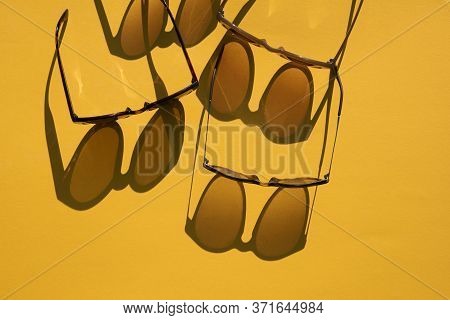 Sunglasses With Long Shadow On A Brignt Summer Yellow Background