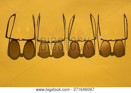 Sunglasses With Long Shadow On A Brignt Summer Yellow Background