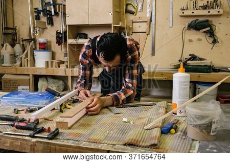 Working Process In The Carpentry Workshop.a Man In Overalls Works In A Carpentry Workshop.profession