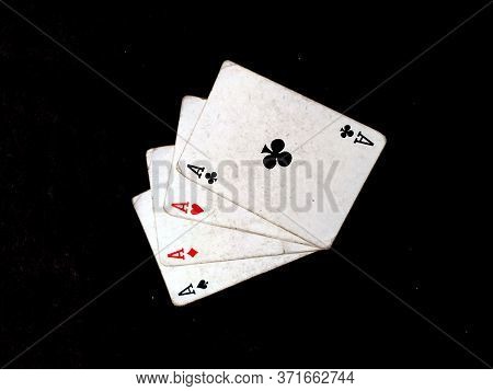 Set Of Four Aces Playing Cards Suits. Winning Poker Hand Isolated On Black Background