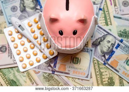 Piggy Bank In A Mask On A Background Of American Currency.the Concept Of Coronavrius Epidemic