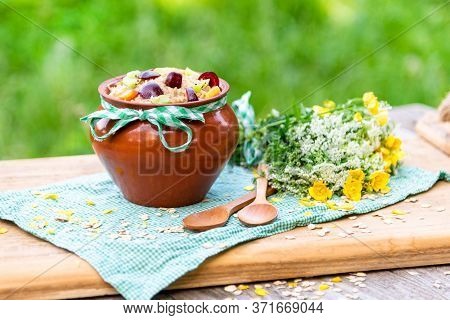 Oatmeal Kacha With Pieces Of Fruit And Berries In A Clay Pot On A Green Checkered Napkin. Delicious 