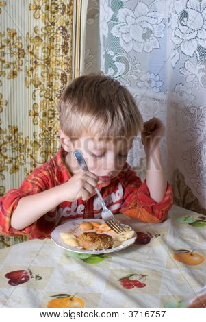 その少年は夕食を持っています。