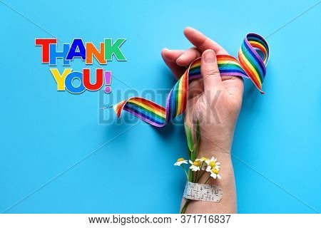 Thank You Doctors And Nurses Rainbow Ribbon In Hand Of Mature Woman With Chamomile Flower And Grass 