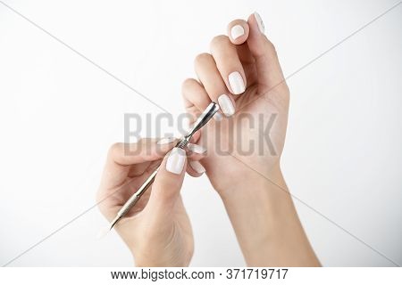 Picture Of Hands Using Cuticle Pusher While Doing Manicure On Isolated While Background