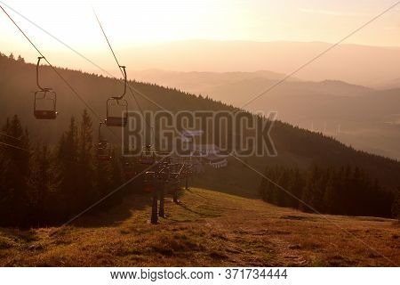 Ski Chair Lift In The Mountains At Red Sunset