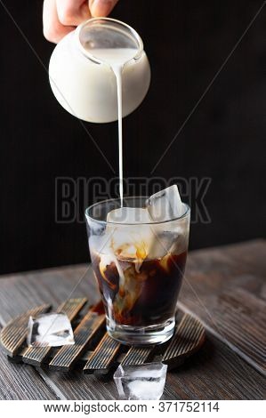 Jug Pouring Imilk Nto The Glass Cup With Ice Coffee. Refreshment Beverage Image For Menu