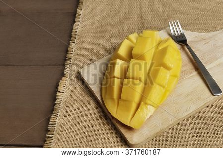 Yellow Half  Mango With Small Fork. Mango Fruit Cubes On The Wooden Table. Tropical Fruit Asia. Fres