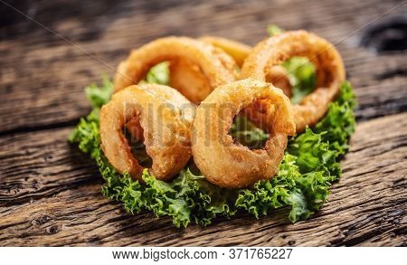 Cripsy Onion Rings On A Lettuce Leaf Placed On A Rustic Wood.