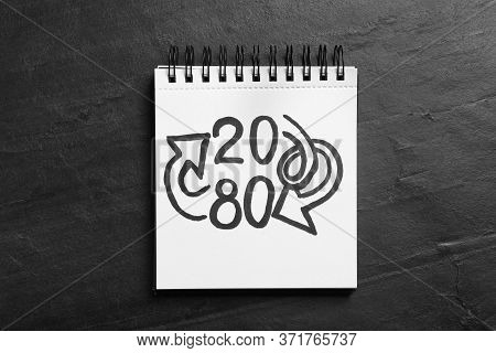 Notebook With Numbers 20, 80 And Arrows On Black Slate Background, Top View. Pareto Principle Concep