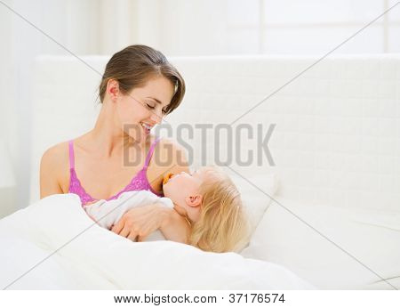 Jovem feliz mãe bebê para dormir de exploração