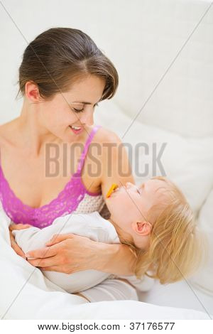 Sorrindo exploração jovem mãe bebê para dormir