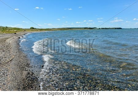 empty shore of the lake waves and blue sky
