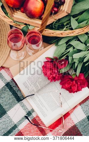 Mood reading a picnic book under a glass of red wine
