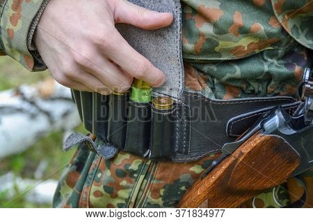 a man hunter takes out ammunition to load the gun